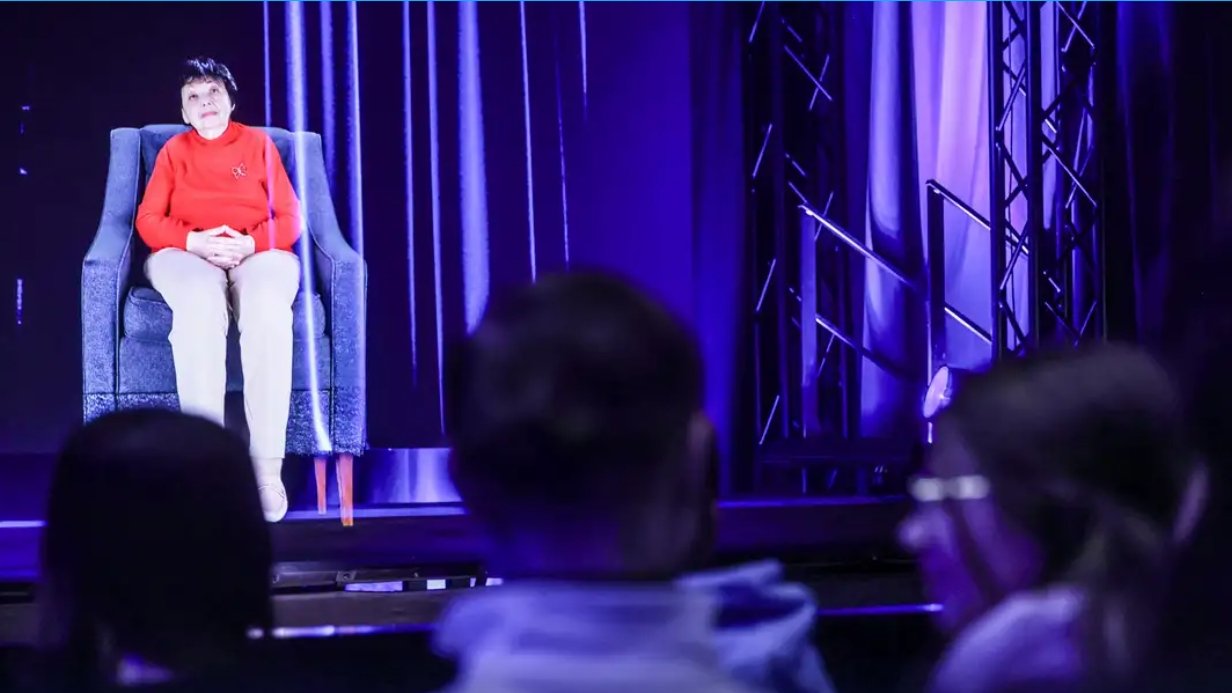 Pessoas diante de holograma de Inge Auerbacher, 91 anos, judia e sobrevivente do Holocausto