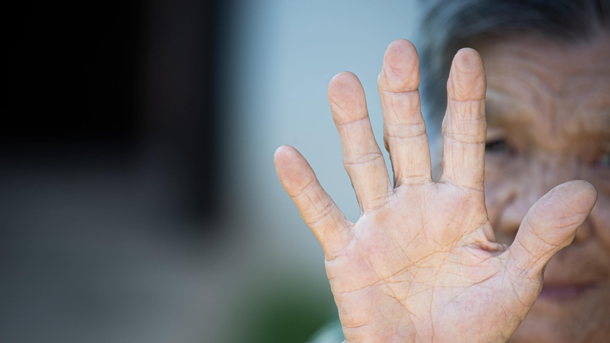 Mão de mulher idosa com destaque para as digitais